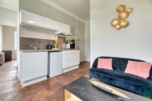 un soggiorno con divano e cucina di Le Rêve doré proche de la Gare ! a Rouen