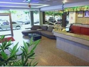 a lobby of a restaurant with a couch and a counter at Royal Hotel in Bintulu