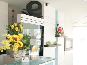 a vase of yellow flowers on a glass table at e Hotel in Malacca