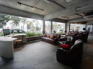 a large living room with couches and a table and windows at Riverine Garden Hotel in Cukai