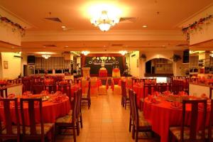 a restaurant with tables and chairs with red table cloth at Li Hua Hotel Bintulu in Bintulu