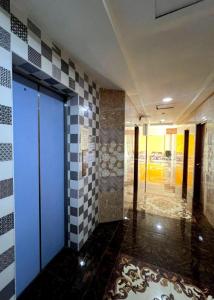 un couloir aux murs à damier et à la porte bleue dans l'établissement Putra Heights New Wave Hotel, à Kampong Pulas 45 autres photos