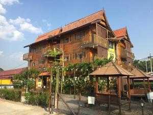 a large wooden building with a porch on the side of it at Kampong Pinang Sebatang Melaka in Pengkalan Balak