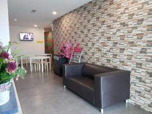 eine Lobby mit einer Ledercouch und einer Backsteinwand in der Unterkunft Hotel Bestari Prima in Kuala Lipis