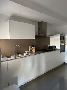 eine Küche mit weißen Schränken und einer Spüle in der Unterkunft El Balcón de Huéscar in Huéscar