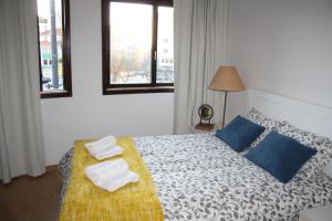 a bedroom with a bed with two towels on it at Alegria Rooms in Porto