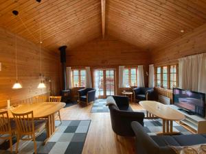 un soggiorno con tavoli, sedie e TV di Family-Friendly Holiday Home In Scenic Nature a Læsø