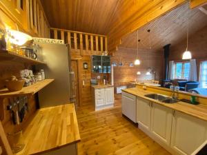 una grande cucina con pavimenti in legno e frigorifero di Family-Friendly Holiday Home In Scenic Nature a Læsø