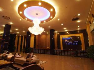 a large lobby with couches and a large light fixture at Paragon City Hotel in Kampong Simee