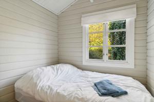 a bed in a room with a window at Lovely Summer House In North Zealand in Vejby