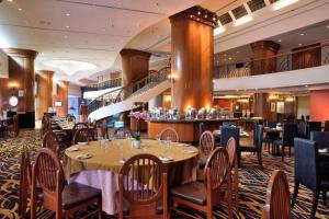 ジョージタウンにあるHotel Royal Penangのテーブルと椅子とバーのあるレストラン