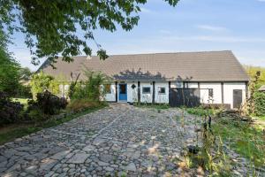 a house with a stone driveway in front of it at Cozy Summer House On Bornholm in Neksø