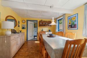 a kitchen with a large dining table and chairs at Cozy Summer House On Bornholm in Neksø
