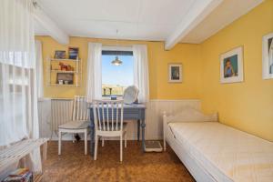 a bedroom with a desk and a bed and a desk at Cozy Summer House On Bornholm in Neksø