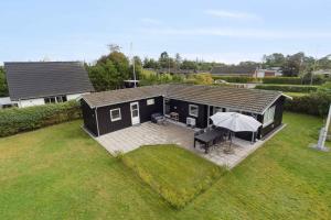 an overhead view of a black house with an umbrella at Lovely Summer House In Øster Hurup in Hadsund