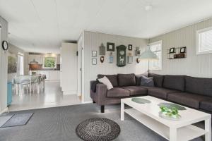 a living room with a couch and a table at Lovely Summer House In Øster Hurup in Hadsund