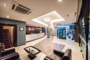 a living room with two couches and a tv at Aston Boutec Hotel Lintas Plaza in Kampong Nasob