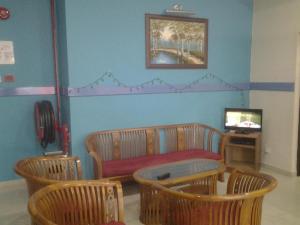 a living room with a couch and chairs and a television at Sea Front Hotel Port Dickson in Kampong Arab