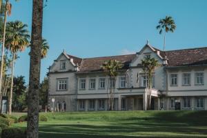 a large house with palm trees in front of it at Zotel Business & Leisure Hotel in Kampong Tabuan