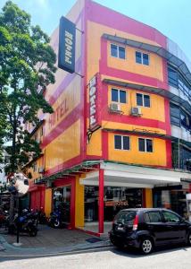 a colorful building with a car parked in front of it at Hartamas Business Hotel in Kuala Lumpur