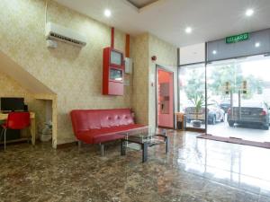 a waiting room with a red couch in a lobby at Hotel Zamburger Sungai Besi in Kuala Lumpur