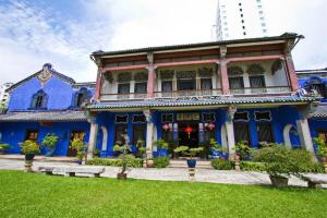 a blue and white house with a green yard at The Chambers Hotel in George Town