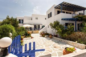une villa avec une clôture bleue et une maison dans l'établissement Theologos Place, à Antiparos