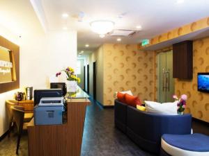 a hospital room with a couch and a desk at Tropicana Boutique Hotel in Kampung Tanjung Agas