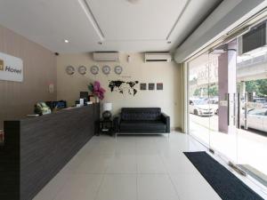 un hall avec un canapé en cuir noir dans un magasin dans l'établissement OYO 131 Dejaya Hotel Kota Damansara, à Kota Damansara