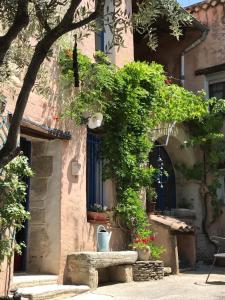 ein Gebäude mit Topfpflanzen vor einem Fenster in der Unterkunft Chambre d'hôte Les Oulies Bédoin in Bédoin