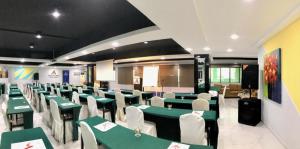 a dining room with green tables and white chairs at Adamson Hotel Kuala Lumpur in Kuala Lumpur
