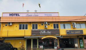 ein gelbes Gebäude mit einem Hotel darüber in der Unterkunft Twin Star Hotel in Kampong Keteyong