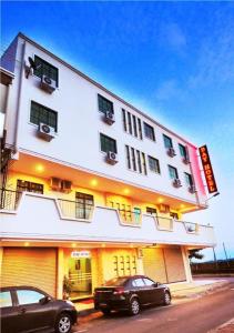 a building with two cars parked in front of it at Bay Hotel in Lahad Datu