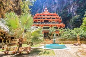 an orange building with a palm tree in front of it at Kinta Valley Retreat in Ipoh