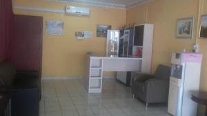 a kitchen with a desk with a refrigerator and a chair at Mawanza Motel in Langkawi Islands +37 photos