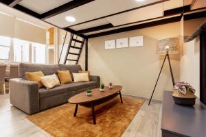 salon z kanapą i stołem w obiekcie Tirso Loft en Madrid w Madrycie
