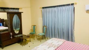 ein Schlafzimmer mit einem Bett, einem Spiegel und Stühlen in der Unterkunft Hyderabad bungalow in Hyderabad + 4 Fotos