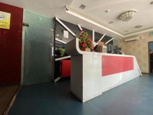 a lobby with a counter with flowers on it at OYO 89752 7 DAYS EXPRESS HOTEL in Batu Pahat