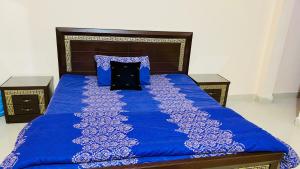 ein blaues Bett mit einer blauen Bettdecke und Kissen in der Unterkunft Hyderabad bungalow in Hyderabad