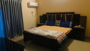 ein Schlafzimmer mit einem Bett mit blauen Kissen in der Unterkunft Hyderabad bungalow in Hyderabad