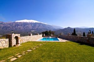 una piscina en un patio con una montaña al fondo en Aposeti Villas en Petrochori