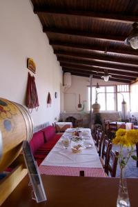 a dining room with a long table and red chairs at Aposeti Villas in Petrochori