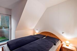 un lit avec des oreillers bleus dans une chambre avec une fenêtre dans l'établissement ruhig gelegene Ferienwohnung, à Röbel