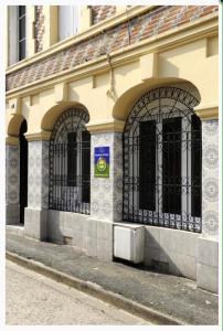 un edificio con puertas negras al lado de una calle en Chambre D'hôtes Anzi, en Arcis-sur-Aube