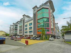 a large building with cars parked in a parking lot at OYO 90484 Bright Hotel in Sungai Way