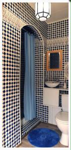 a bathroom with a blue and white tiled wall at Chambre D'hôtes Anzi in Arcis-sur-Aube