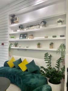 a living room with a green couch and some plants at ATAP Hotel in Kota Kinabalu