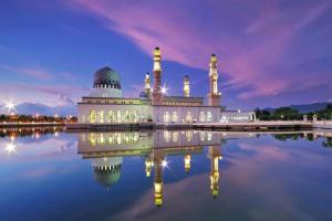 a mosque with its reflection in the water at night at ATAP Hotel in Kota Kinabalu