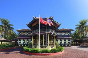 a building with two flags in front of it at OYO 90535 Wakaf Bharu Inn in Kota Bharu