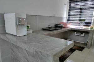a kitchen with a marble counter top with a refrigerator at OYO Homes 90611 Homestay D'emas in Melaka +9 photos